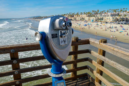 Sightseeing retro style binoculars with beach background Oceanside Pier in San Diego, California, USA. Famous travel destination in the South West Coast. January 2nd, 2021のeditorial素材
