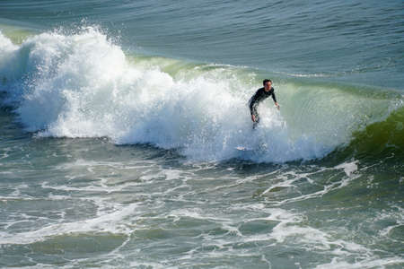 Male surfers enjoying the big wave in Oceanside in North San Diego, California, USA. Travel...