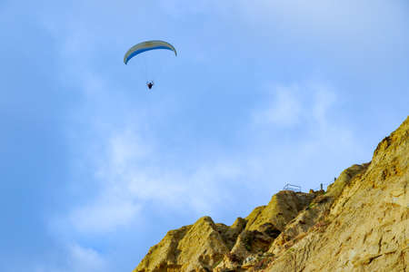 Man doing sport, Para-glider in the clouded sky. Paragliding is an extreme sport and recreation. Torrey Pines Gliderport. San Diego. California, USA.の写真素材