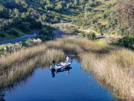 Aerial view of fishers and their fishing rods trying to catch fish on a small motor boat at the Miramar lake, San Diego, California. USA. March, 18th, 2020のeditorial素材