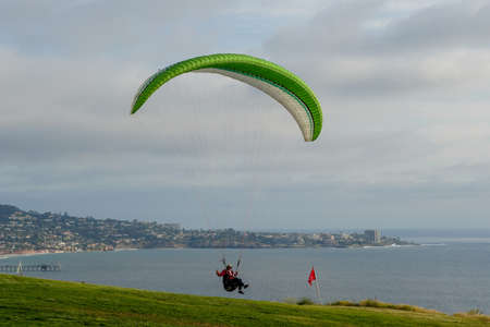 Man doing sport, Para-glider in the clouded sky. Paragliding is an extreme sport and recreation. Torrey Pines Gliderport. San Diego. California, USA. March 22nd, 2021のeditorial素材