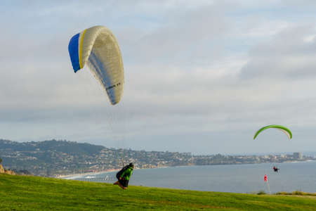 Man doing sport, Para-glider in the clouded sky. Paragliding is an extreme sport and recreation. Torrey Pines Gliderport. San Diego. California, USA. March 22nd, 2021のeditorial素材