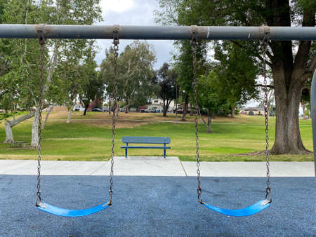 Swings at children playground activities in public park. swing on modern playground. Urban neighborhood childhood concept.の写真素材