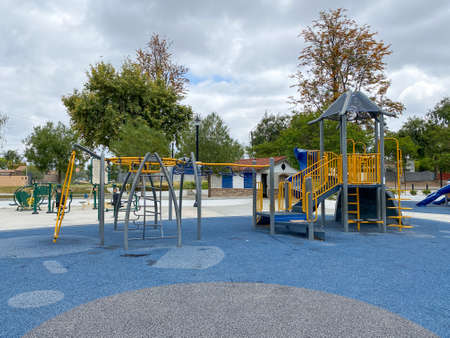 Children playground activities in public park. Slide, swing on modern playground. Urban neighborhood childhood concept.の写真素材