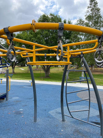 Children playground activities in public park. Slide, swing on modern playground. Urban neighborhood...