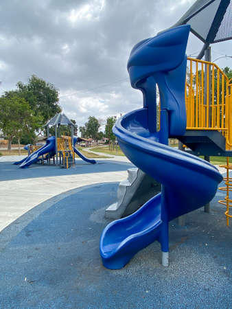 Slide, swing on modern playground. Children playground activities in public park. Urban neighborhood...