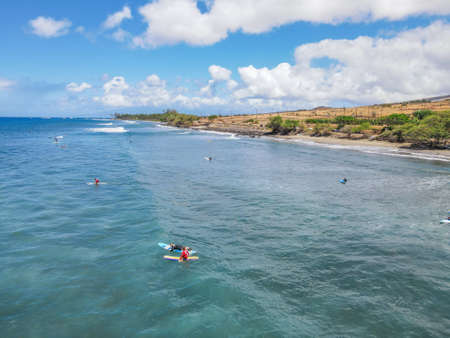Aerial pic of surfers seating on surfboards and waiting for wave in the middle of ocean with perfect...