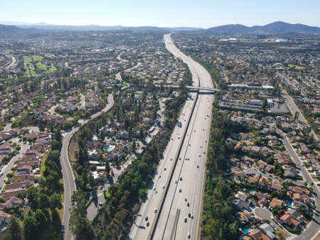 Aerial view of highway with traffic surrounded by houses, Interstate 15 with in vehicle movement....