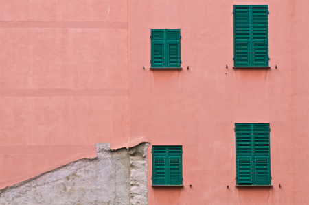 Four closed green window on a wall with flaking paint.の写真素材