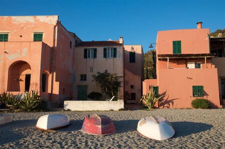 Three boats upside down at the sunset on the beach of the traditional town of Varigotti, Liguria, Italy.の写真素材