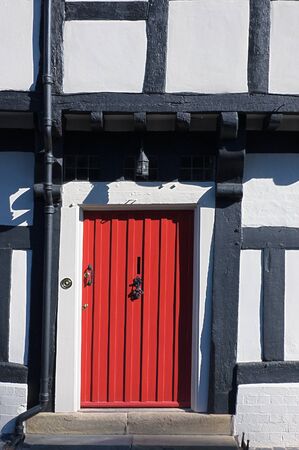 Red entrance door on a half timbered Tudor cottageの写真素材