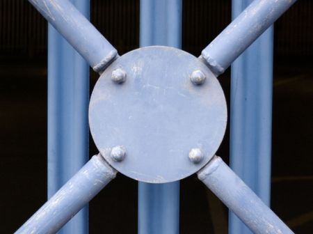 Blue sheet metal boundary fence with circular disc and crisscross strutsの写真素材