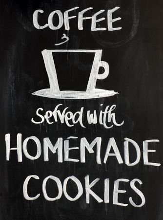 Blackboard sign with a cup motif and the words - Coffee served with homemade cookies. White on a black backgroundの写真素材