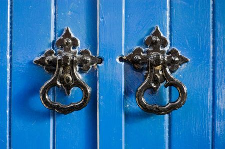 Two black door knockers on a blue doorの写真素材