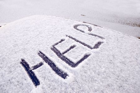 Snow covered car with the word help written on the roofの写真素材