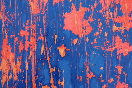 Background texture of orange and blue paint peeling off a metal plateの写真素材