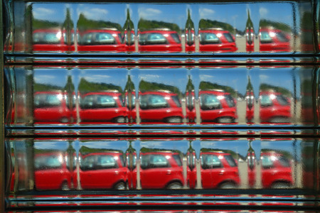 Abstract view of a red car seen repeated through a glass brick.