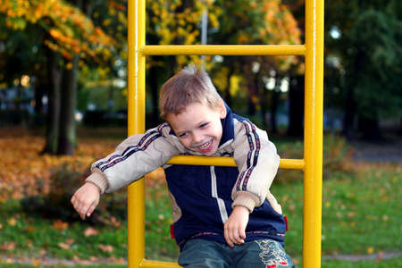 The cheerful little boy playing at playground