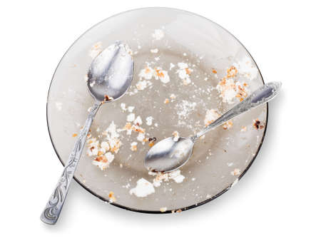 Empty dirty plate with spoons isolated on the white backgroundの写真素材