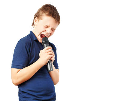 Teenage boy singing into a microphone on a whiteの写真素材