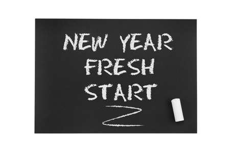 Inscription in chalk on black paper: New year, fresh start. The concept of life from scratch, a new...