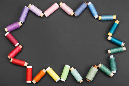 Coils with coloured threads in the shape of a cloud or star on a black background. The concept of...
