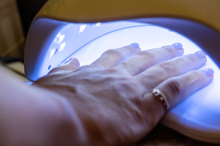 The procedure of polymerization, drying of varnish applied to the nails of the hand, manicure in the salon, at home. High quality photoの写真素材