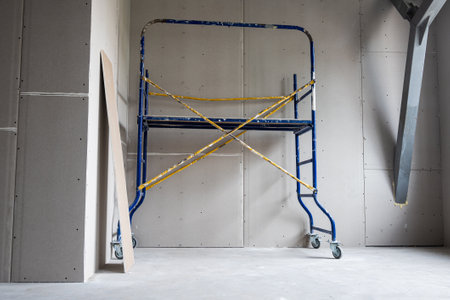 Construction mobile scaffolding is located in a room sheathed with plasterboard. Repair, scaffolding, drywall. High quality photoの写真素材