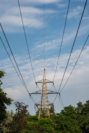 high-voltage electricity line, against the background of the sky, green trees. High quality photo
