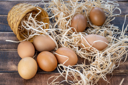 Homemade chicken eggs. Eggs in a wicker basket. Eggs on straw. Brown homemade chicken eggs. High quality photoの写真素材