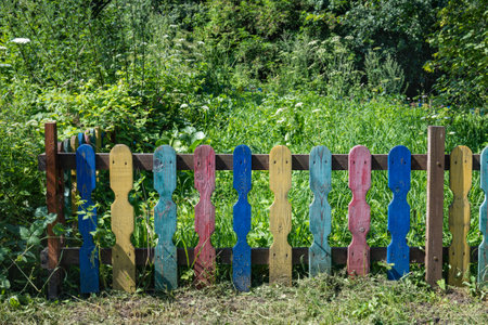 Colorful wooden fence near the green garden. Grass with trees in the garden. High quality photoの写真素材