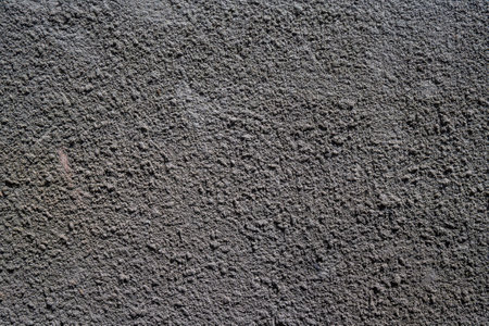 grey, concrete wall with a pronounced grainy reliefの写真素材
