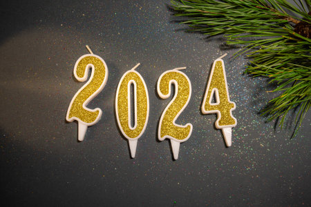 Beautiful Christmas background with the date 2024 on a gray background with sparkles, spruce and...