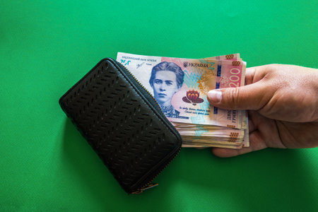 A pack of Ukrainian 200 hryvnia with a wallet on a green background