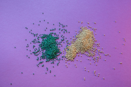 two heaps of beads, green and gold on a purple background