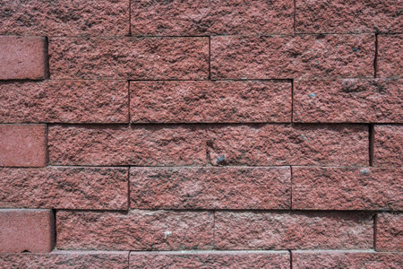 texture of a wall with red stone bricks with a grungy reliefの写真素材