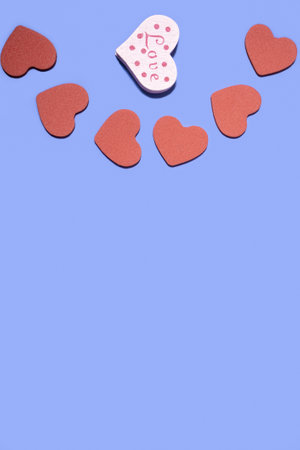 Wooden hearts on a pastel blue background. Concept for Valentines Day, Mothers Day, World Womens Day. Romantic flat composition.の写真素材