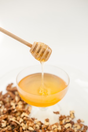 Honey natural with a wooden spoon on a white backgroundの写真素材