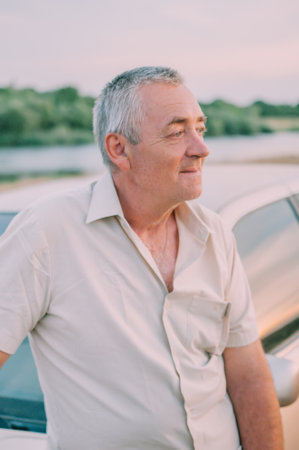 Smiling happy elderly old man in the new carの写真素材