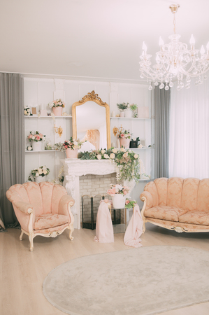 The interior is festive with white wooden vintage arch, beautiful pink chair, flowers, glowing garlands and decorations, photozoneの写真素材