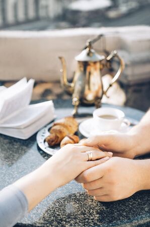 hands of young lovers holding a hot cup of coffee or teaの写真素材
