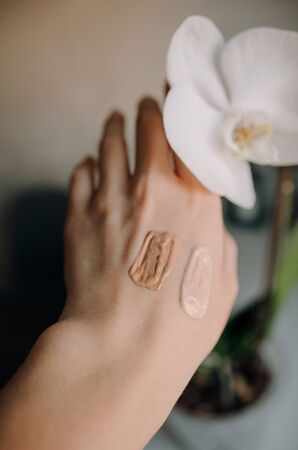 Swatch of tonal foundations of different colors on the girl's handの写真素材