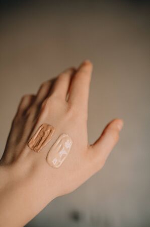 Swatch of tonal foundations of different colors on the girl's handの写真素材