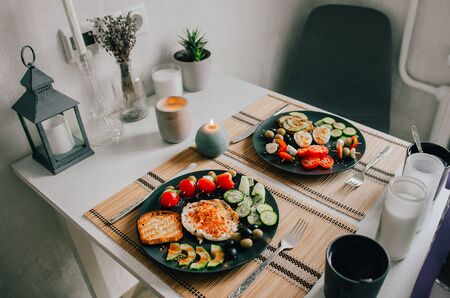 Appetizing food in a beautiful black dish on a table in the house. Vegetables, healthy breakfast.