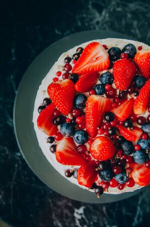 Delicious tart with fresh strawberries, raspberries and currants on the table. top view horizontalの写真素材