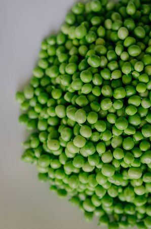 Green peas on a green tablecloth in the kitchenの写真素材