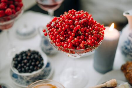 Breakfast at home. Red currant in focus. Against the background of berries, coffee, honey,...