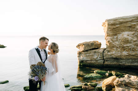 Wedding photo of a couple in love on the seashore at sunrise.の写真素材