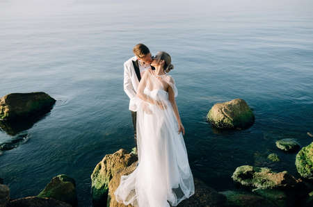 Wedding photo of a couple in love on the seashore at sunrise.の写真素材