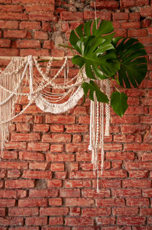 Macrame product on a background of a red brick wall in boho style.の写真素材